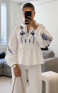 Blouse Hortense blanche à broderies bleues, manches bouffantes, taille smockée et col en V, style bohème chic pour femme.