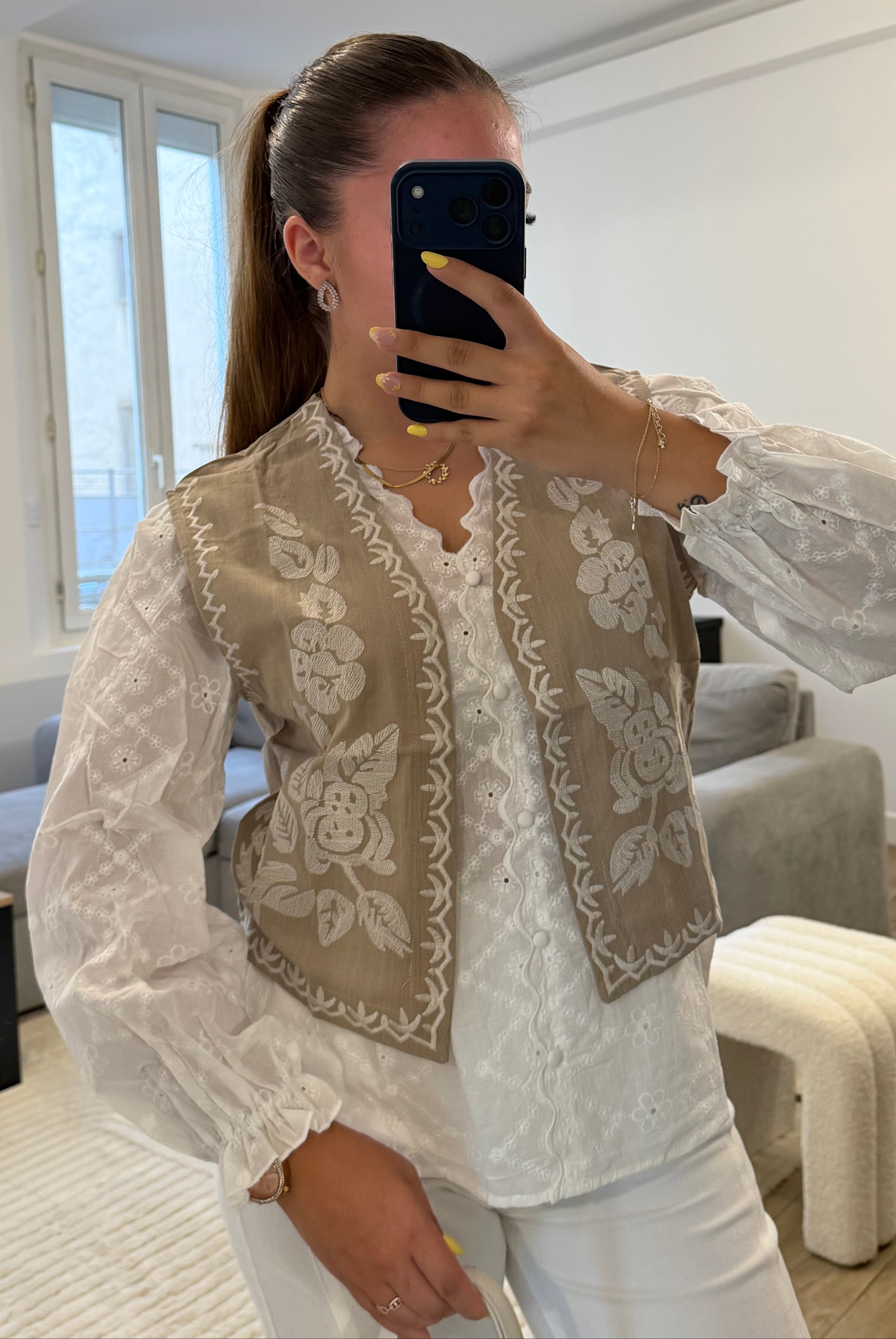 Gilet Ana beige sans manches avec broderies de fleurs blanches, coupe courte et style bohème chic pour femme