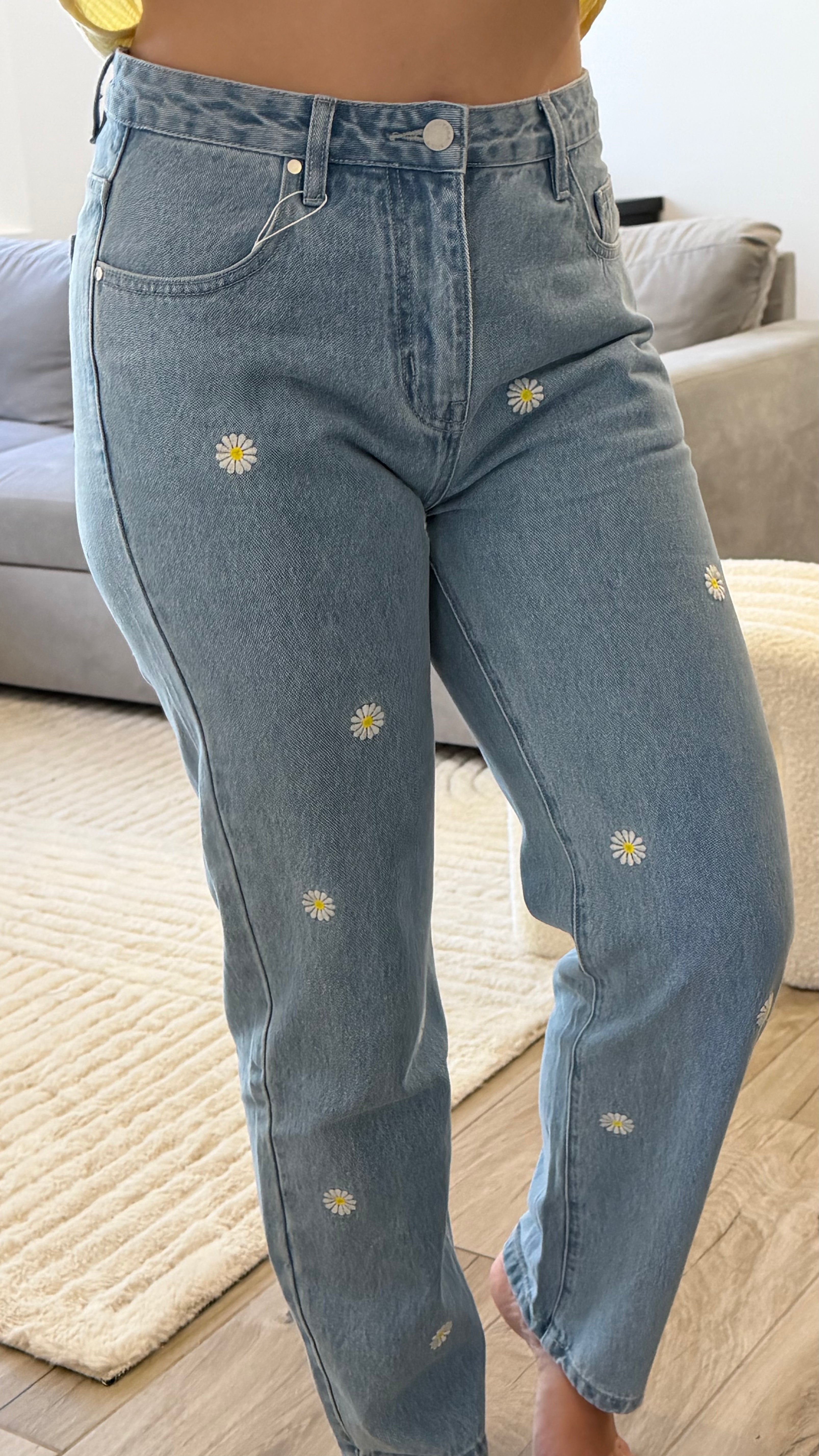 Pantalon Marguerite en jean large bleu clair avec broderies de marguerites.