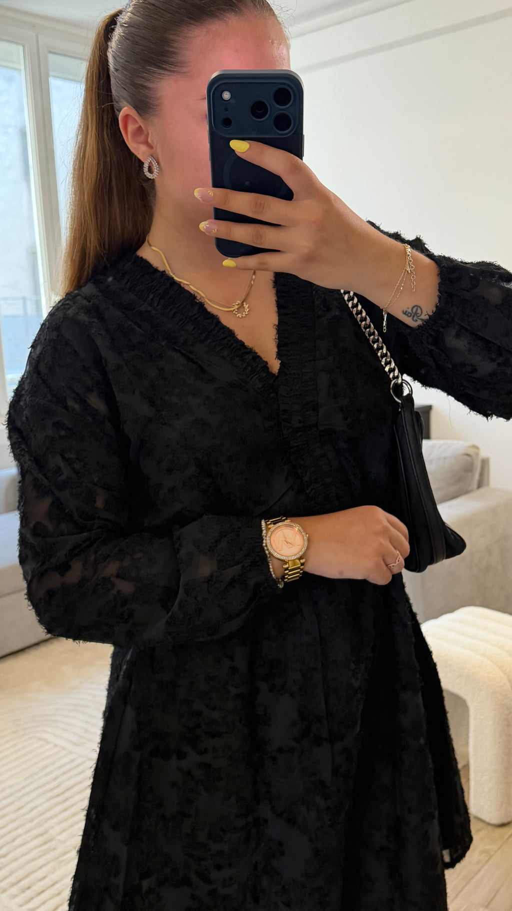 Robe Victoria noire pour femme avec tissu texturé, manches longues, col en V et coupe évasée.
