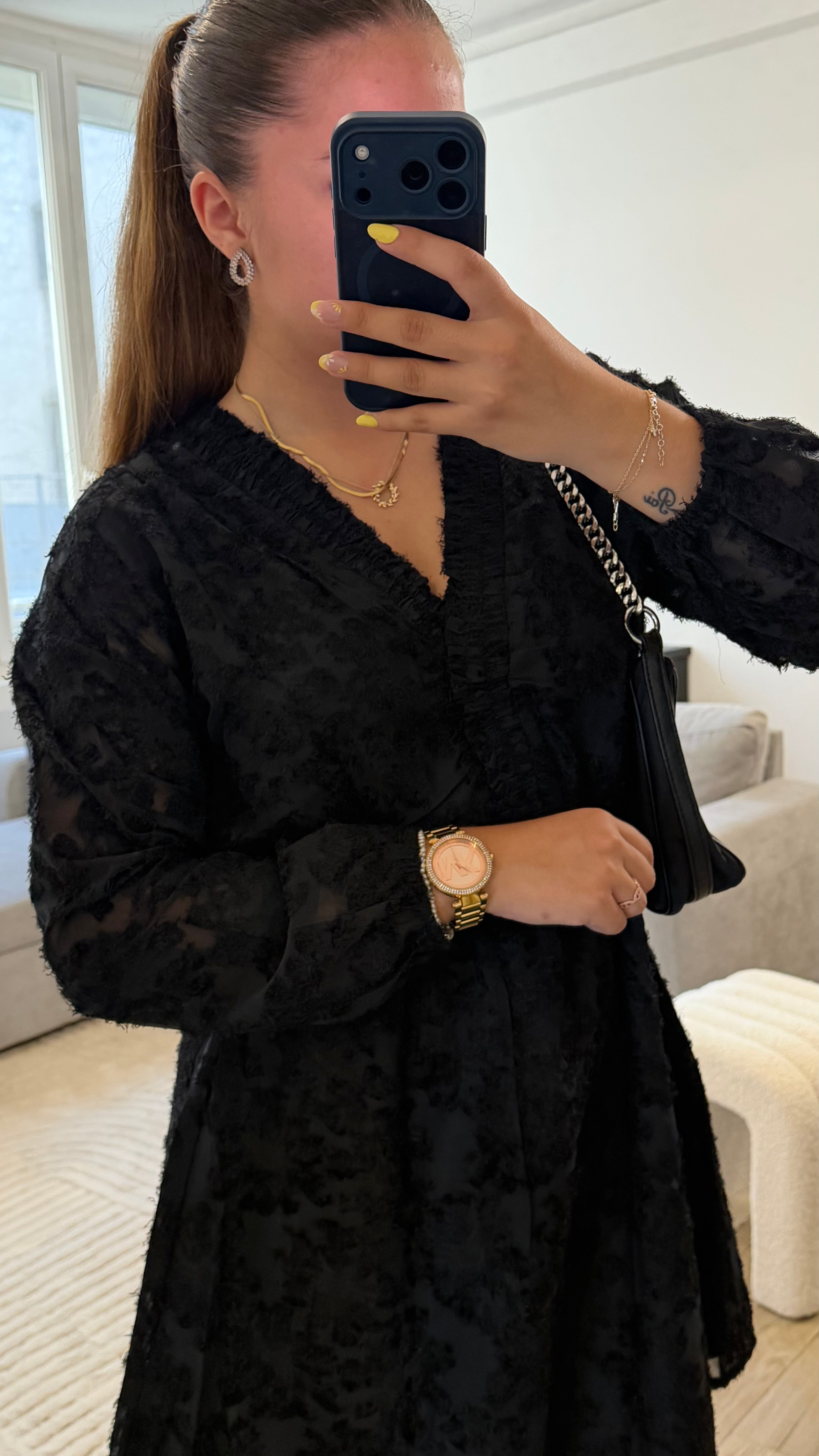 Robe Victoria noire pour femme avec tissu texturé, manches longues, col en V et coupe évasée.