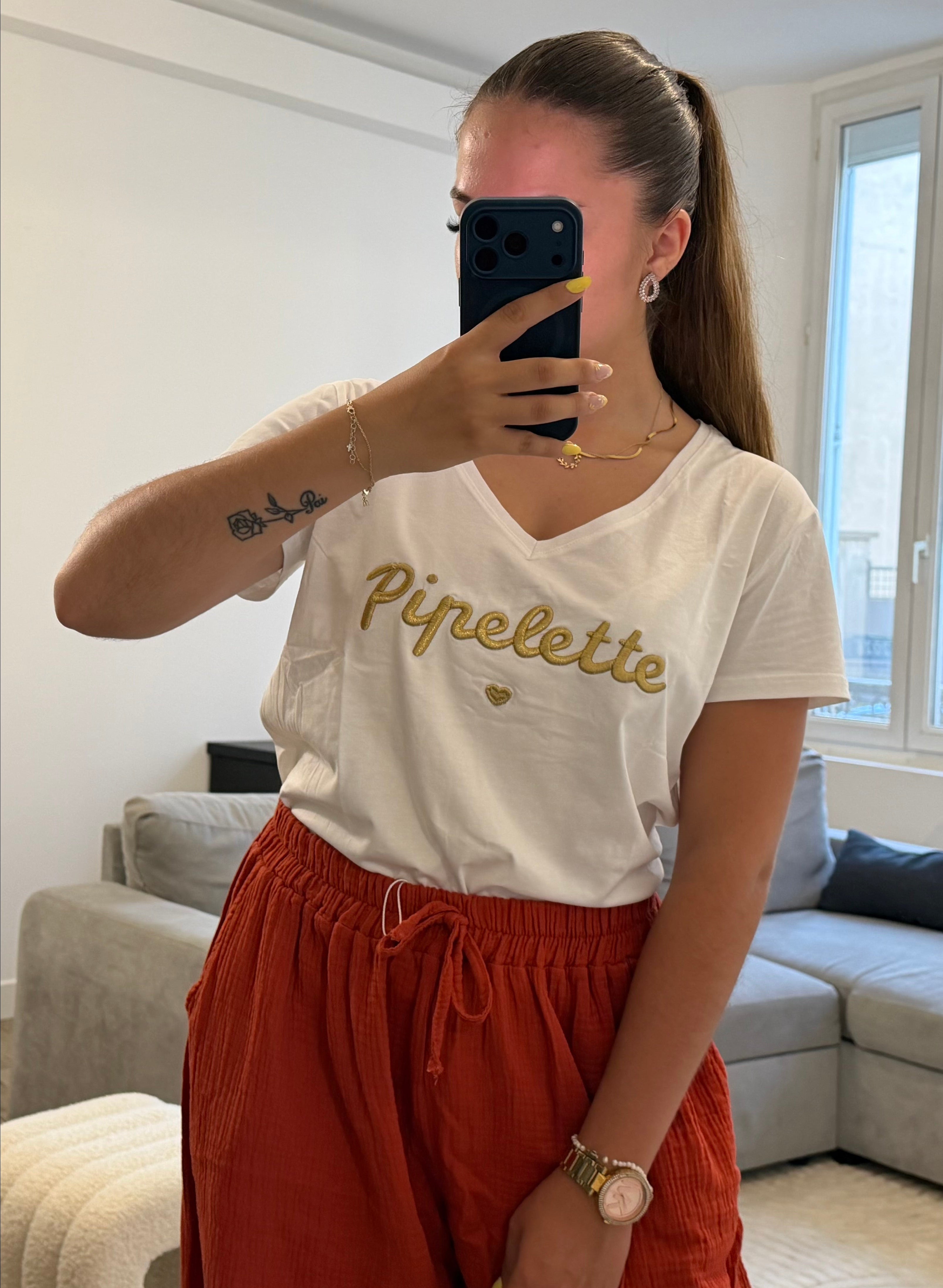 T-shirt blanc pour femme avec broderie dorée "Pipelette" sur la poitrine, coupe confortable et intemporelle.